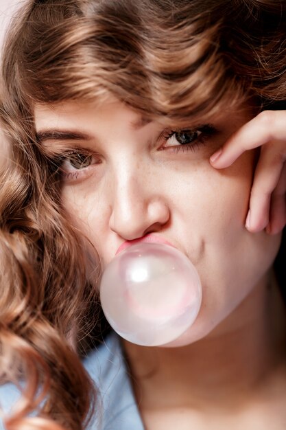 Photo woman doing bubble with chewing gum