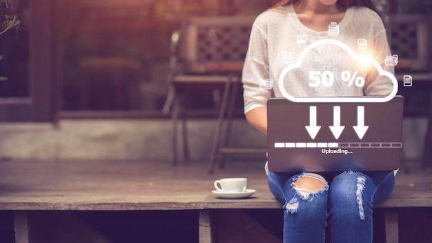 Woman doing cloud uploading on laptop in office Data infomation