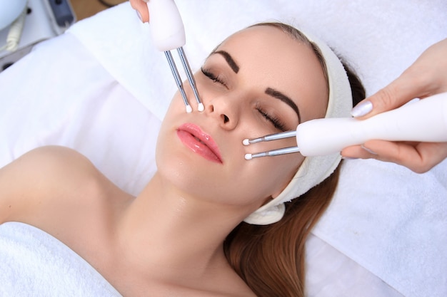 Woman doing cosmetic procedures in spa clinic.