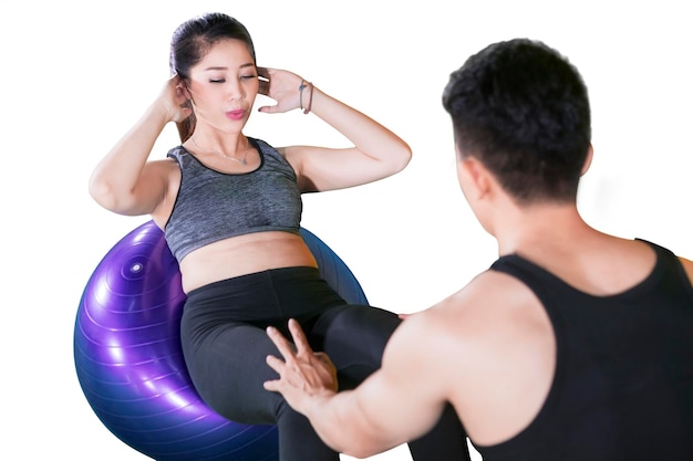 Woman doing crunches exercise with her trainer