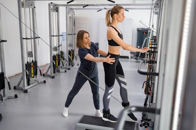 Woman doing exercise on decompression simulators with trainer rehabilitation