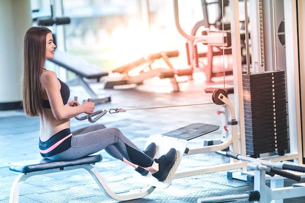 The woman doing exercise on the gym equipment