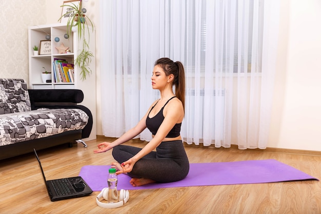 Woman doing exercise in modern interior practicing yoga meditation