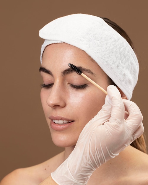 woman doing an eyebrow treatment to her client