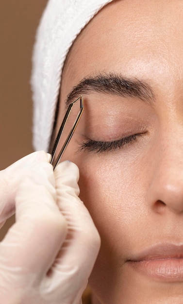 Woman doing an eyebrow treatment to her client