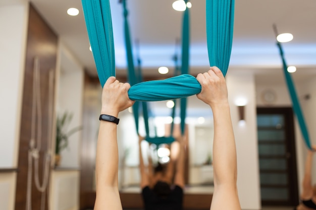 Woman doing fly yoga stretching exercises in gym