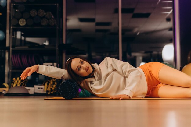 Photo woman doing foam roller exercises to relieve back pain