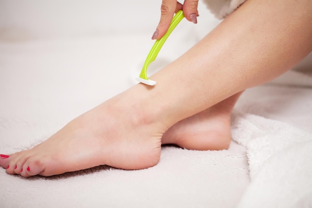 Woman doing hair removal at home in bathroom