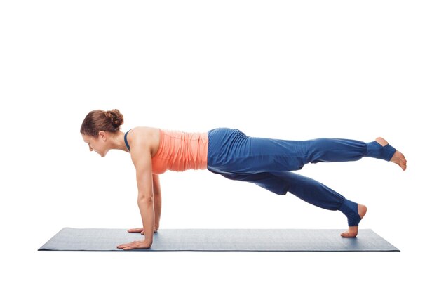 Woman doing hatha yoga asana utthita chaturanga dandasana