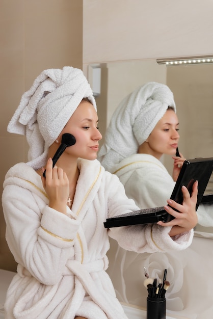 Woman doing herself makeup at home in the bathroom