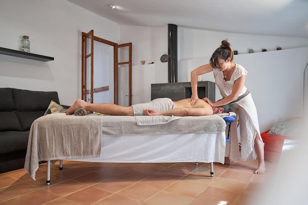 Woman doing massage for man in salon