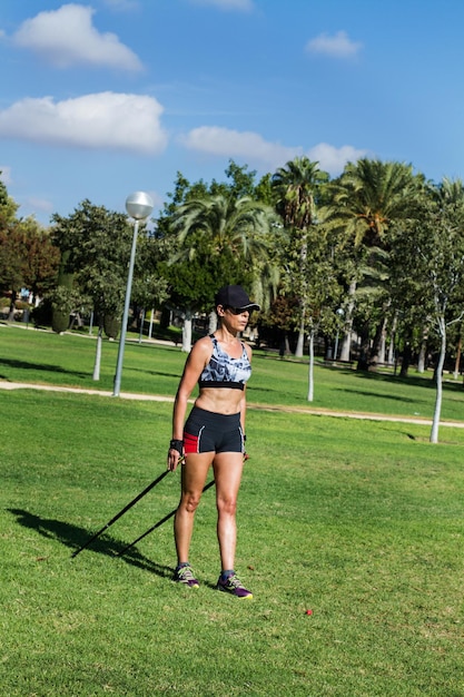 A woman doing nordic walking in the park