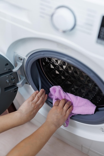 Woman doing periodic maintenance cleaning the washing machine housekeeper washing and cleaning