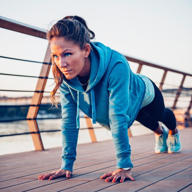 Photo woman doing plank on riverside