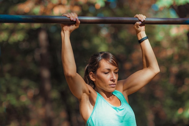 Woman doing pullups in the park