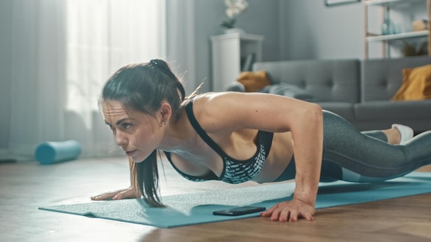 A woman doing push ups in a living room