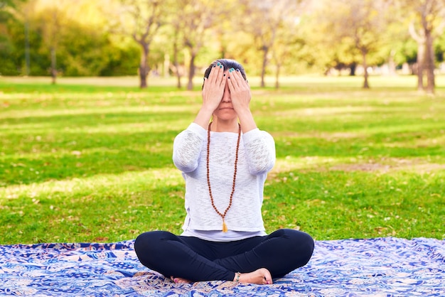 woman doing reiki and yoga pose in a park chakra pose