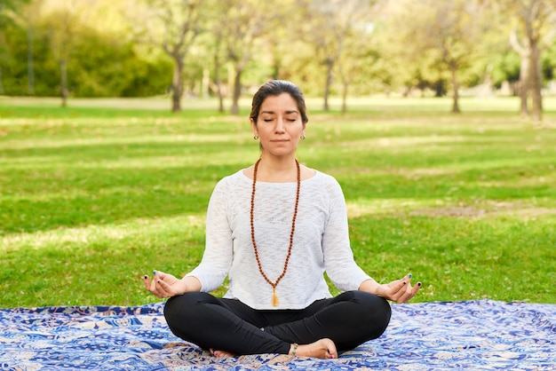 Photo woman doing reiki and yoga pose in a park chakra pose