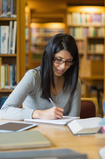 女性は図書館でいくつかの研究をしている