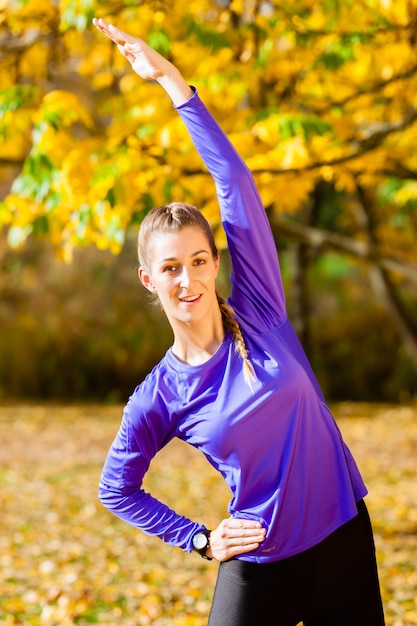 秋の森でスポーツをする女性