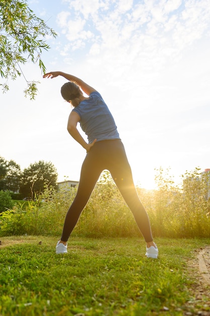 Donna che fa sport in campagna al tramonto