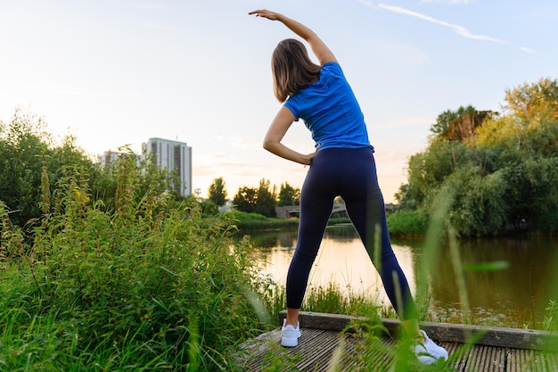 Donna che fa sport in campagna al tramonto