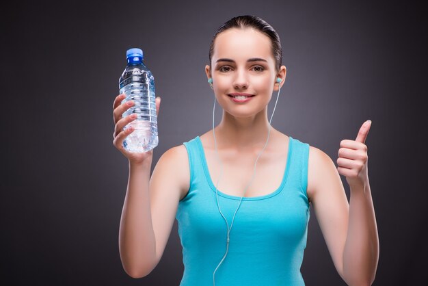 Woman doing sports with bottle of fresh water