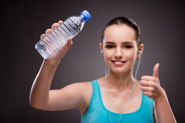 Woman doing sports with bottle of fresh water