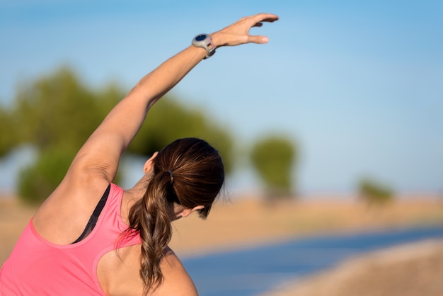 Woman doing stretching exercise for back, sport background.