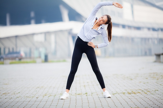 Woman doing stretching exercise on stadium