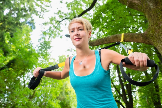 Foto donna che fa lo sport dell'istruttore dell'imbracatura della sospensione