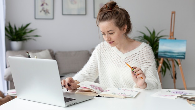 Foto donna che fa un vlog a casa con il suo laptop