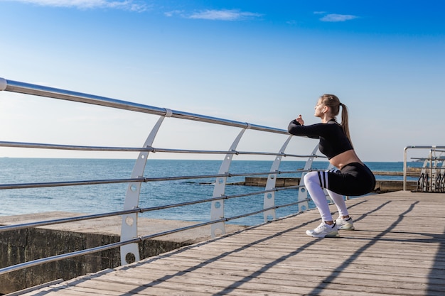 Woman doing warming up exercises and squats.