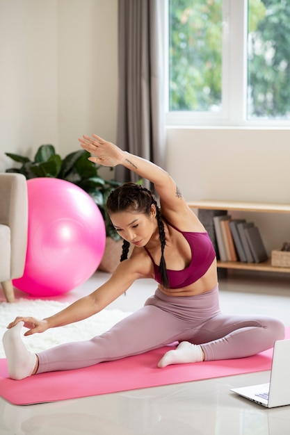 Foto donna che fa yoga dopo un istruttore di fitness online