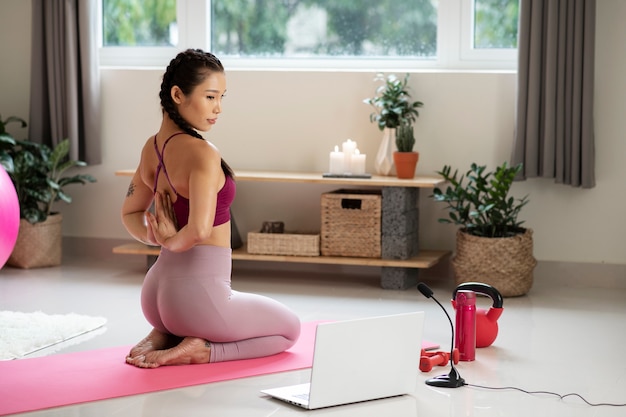 Photo woman doing yoga after online fitness instructor