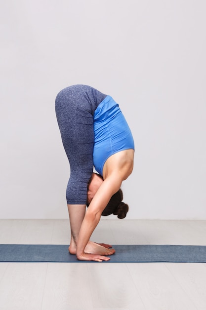 Photo woman doing yoga asana uttanasana - standing forward bend