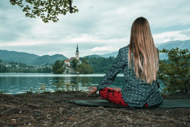 Photo woman doing yoga by lake