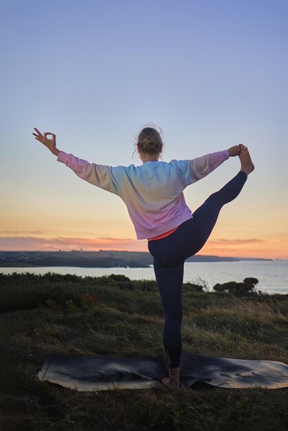 Woman doing yoga in front of the sea international yoga day\
concept