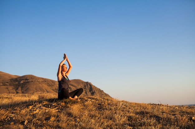 woman doing yoga on nature outdoor at sunrise