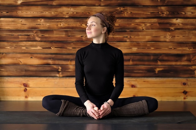 Woman doing yoga or pilates exercise sitting in baddha konasana