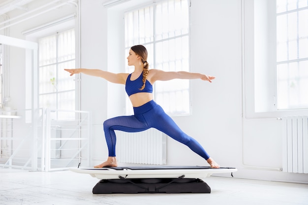 Woman doing yoga pose on fitness surf