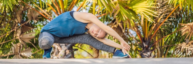 Woman doing yoga in a tropical park banner long format