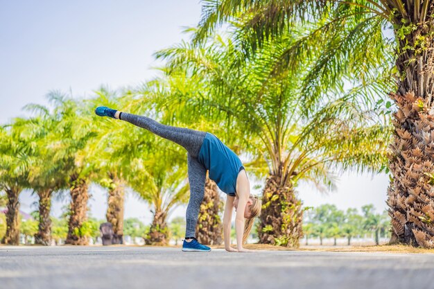 Woman doing yoga in a tropical park