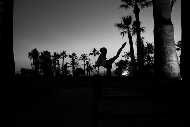 Woman doing yoga in yard at dusk