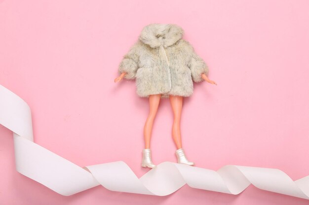 Woman Doll in fur coat on payment tape Minimalism shopping concept Top view Flat lay