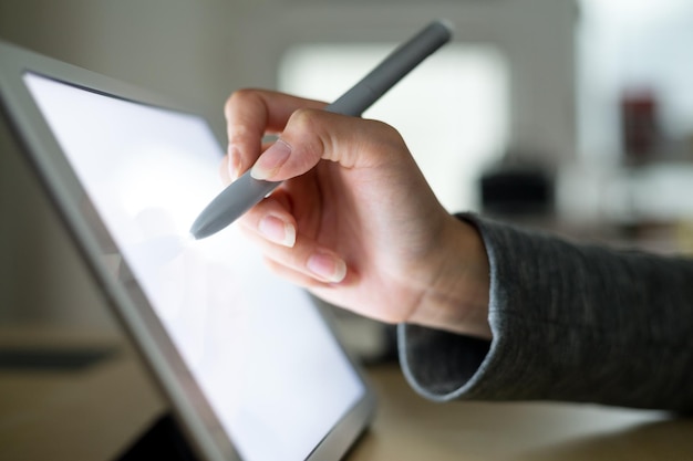 Woman drawing on tablet with pen