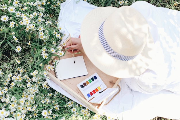 Woman drawing with watercolor outdoors