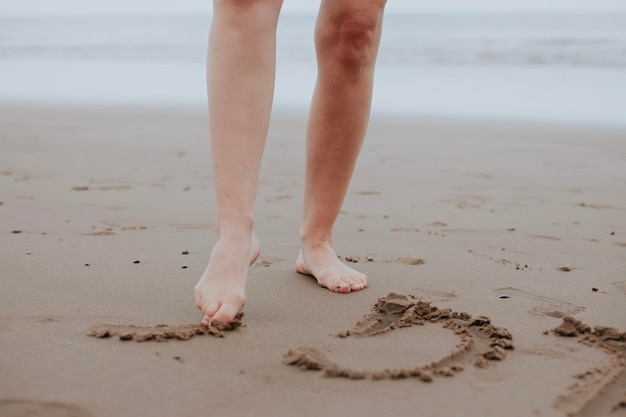 Foto disegni di donne sulla sabbia con i piedi