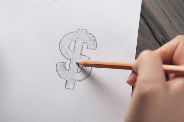 woman draws dollar sign on paper