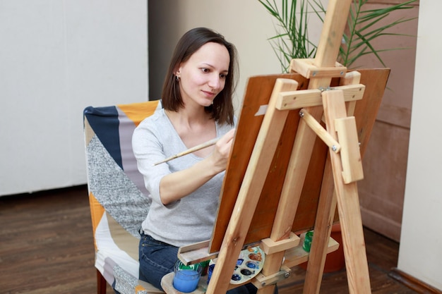 A woman draws on an easel in the workshop hobby